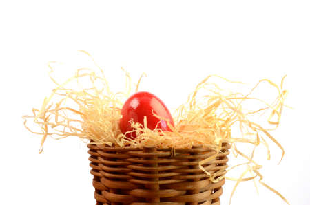 Red Easter egg with straw on a white backgroundの写真素材