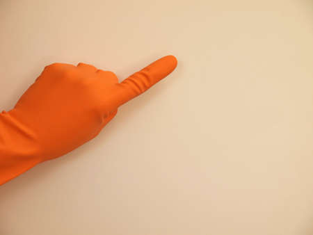 Hand with a rubber glove pointing on something, background with space for text or imageの写真素材