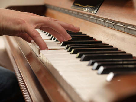 Playing an old upright piano   の写真素材