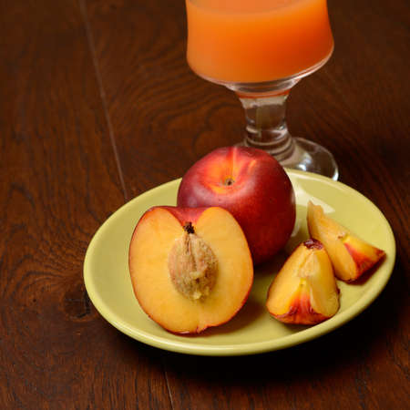 Juice with fresh peaches on an old wooden tableの写真素材