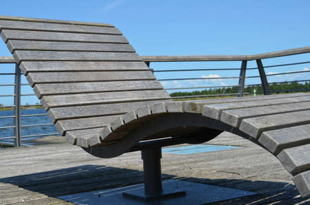 Wooden relaxing chair in front of a seaの写真素材