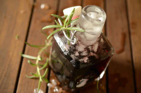 Cold bottle with juice of cherries and chrushed ice cubesの写真素材