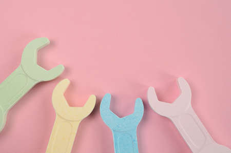 Colorful wrench on a pink background with space for textの写真素材