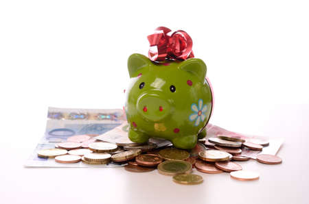 Green piggy bank on money with a white の写真素材
