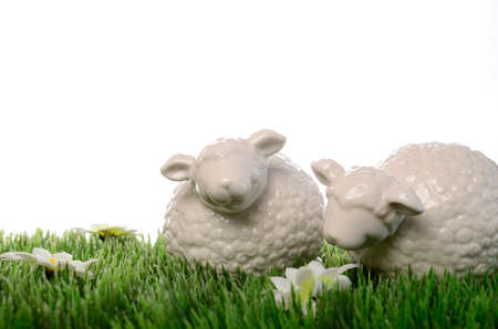 Two ceramic sheep on a green meadow with space for textの写真素材