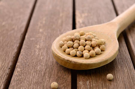 White pepper on a wooden spoonの写真素材