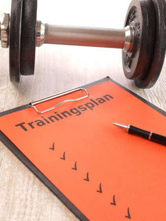 Notebook with a red letter and sports equipmentの写真素材