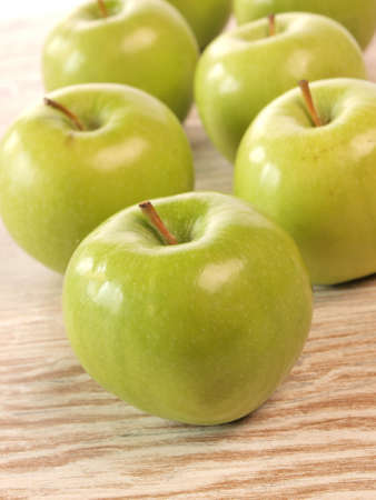 Fresh green apples on a wooden bowlの写真素材