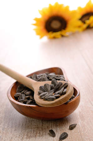 Sunflower seeds on a wooden spoonの写真素材