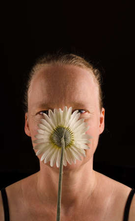 Woman behind a white flower on a dark backgroundの写真素材