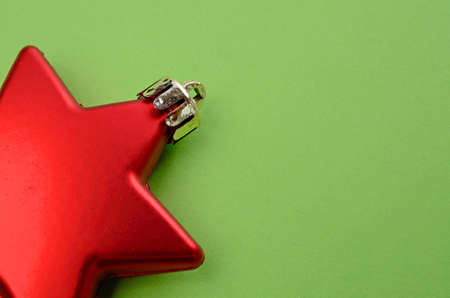 Red Christmas bauble with star shape on a green background