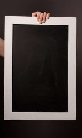 Hand holding a blackboard with space for text or image