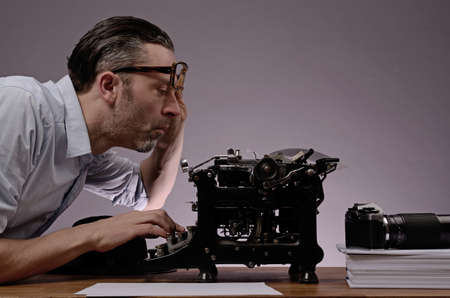 Editor with an old typewriter and retro camera on a wooden office tableの写真素材