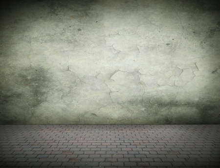 Grunge background with a concrete wall and cobblestone with space for text or imageの写真素材
