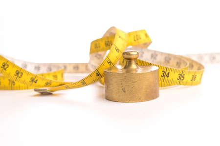 Measuring tape with an old weight on a white backgroundの写真素材
