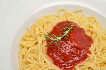 Spaghetti with tomato sauce on a white plateの写真素材