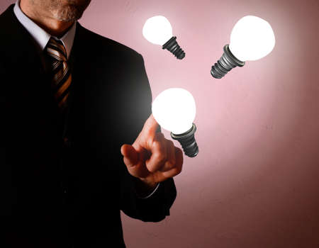 Business man pointing on a light bulb, new idea conceptの写真素材