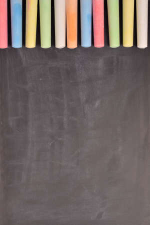 Colorful chalk on a blackboard with space for text or imageの写真素材