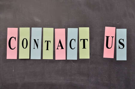 Blackboard with colorful sticky notes and the words Contact us !の写真素材