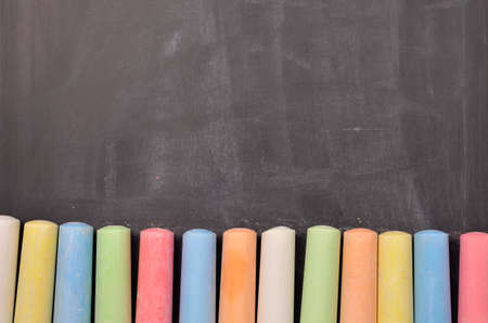 Colorful chalk on a blackboard with space for text or imageの写真素材