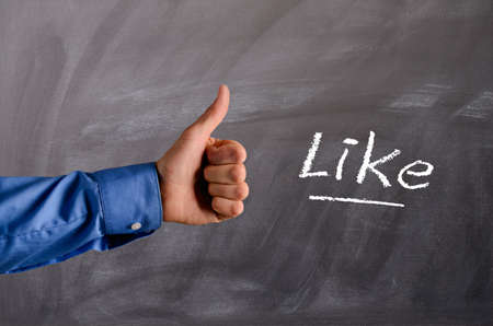 Business man with thumb up on a blackboard