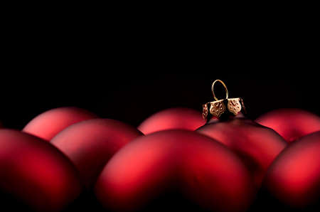Red Christmas baubles on a dark background with space for textの写真素材