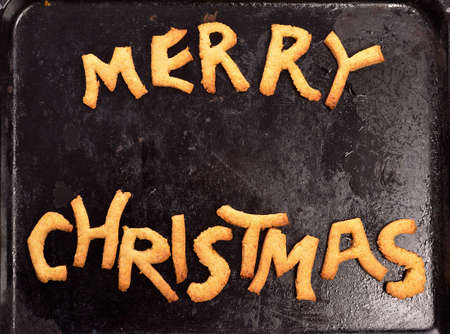 Sweet Merry Christmas cookies on an old used dirty baking plateの写真素材