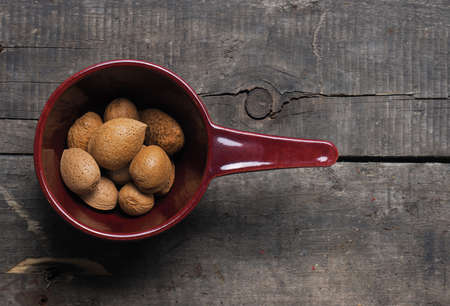 Almonds in a rustic bowl on wood