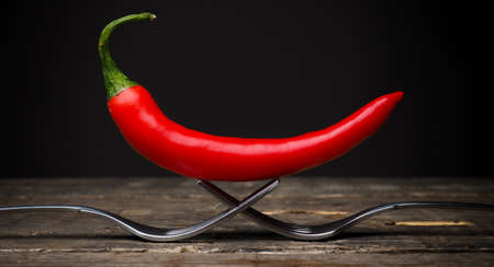Red chili on two forks on an old used table