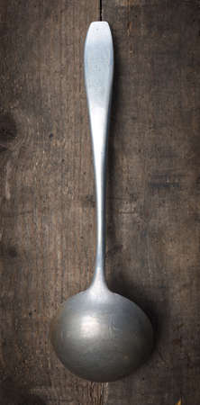 Old used spoon on a rustic wooden tableの写真素材