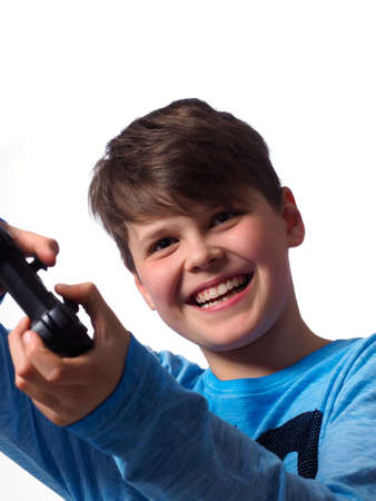 Young boy playing video games on a white studio backgroundの写真素材