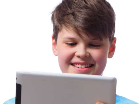 Young boy using a tablet computer, close up studio shot on a white backgroundの写真素材