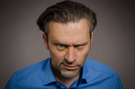 Business man looking crazy on a studio backgroundの写真素材