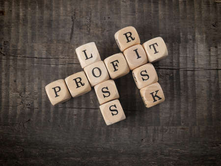 Cross words with the words profit, loss and risk on wooden dicesの写真素材