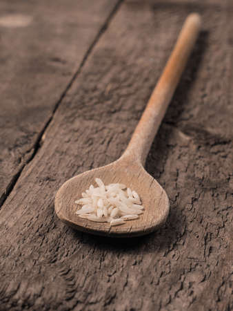 Old used cooking spoon with corns of riceの写真素材