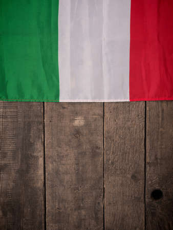Italian flag on an old wooden background with space for text or imageの写真素材