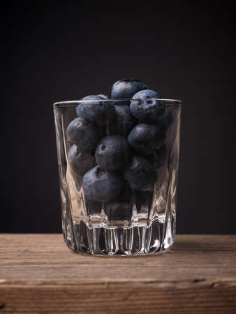 Blueberries in a glass on a wooden table, super food concept imageの写真素材