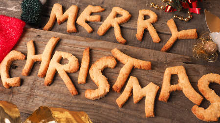 Sweet homemade cookies with the words Merry Christmas on an old wooden tableの写真素材