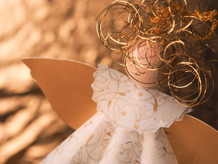Golden homemade angel using as Christmas background, selective focus on the golden hairの写真素材