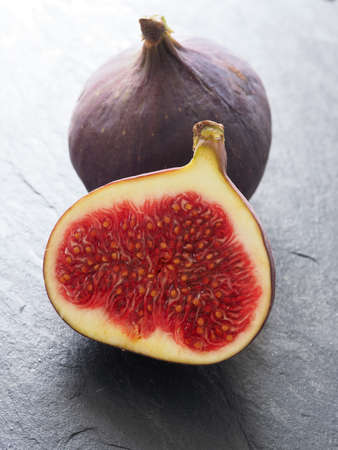 Fresh organic figs on a dark slate background, closeup shotの写真素材