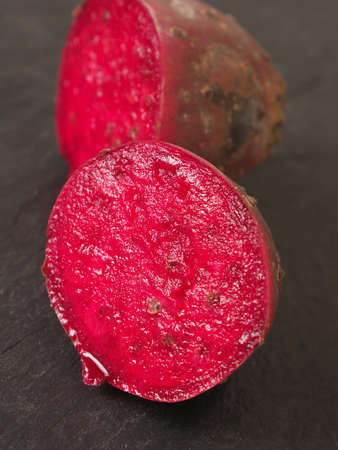 Closeup of a prickly pear on a dark slate plate, selective focus on foregroundの写真素材