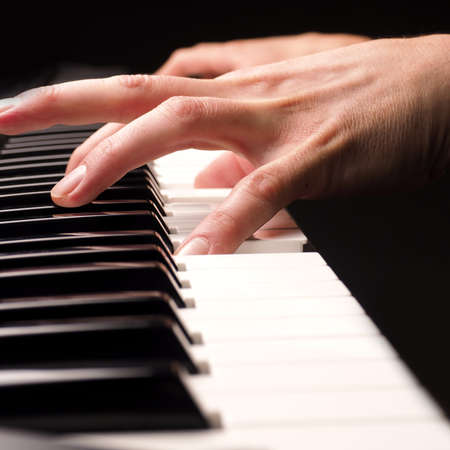 Close up shot of male hands playing piano with selective focusの写真素材