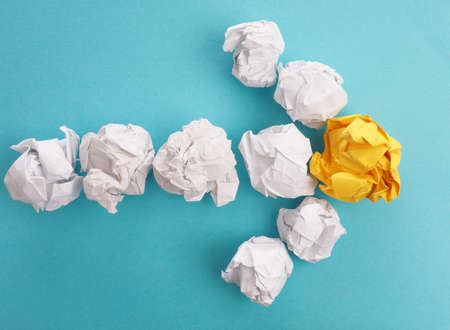 An arrow of crumpled paper on a blue background