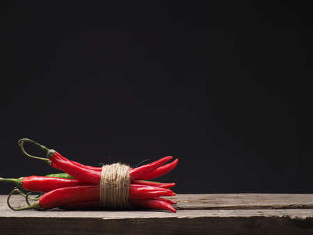 Bunch of chilies on a rustic wooden table with space for text or imageの写真素材