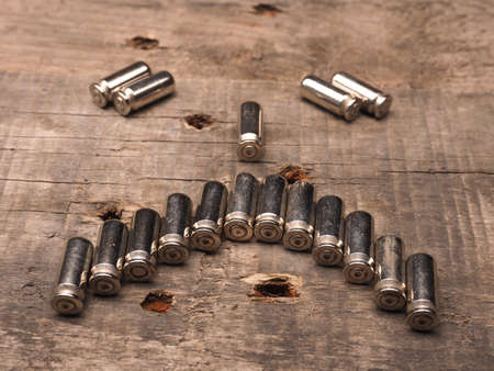 Unhappy face of bullets on a wooden backgroundの写真素材
