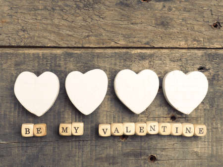 Wooden dices with heart shapes on a rustic wooden background, vintage color toned love concept imageの写真素材