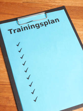 Fitness concept image with a clipboard and the German words workout planの写真素材