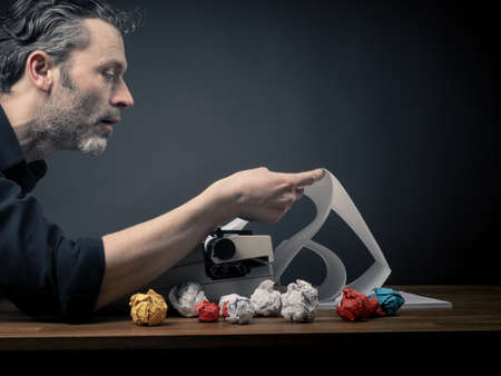 Editaor with his old typewritar at work in his officeの写真素材