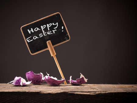 Happy Easter concept image with colorful egg shells on a rustic wooden table