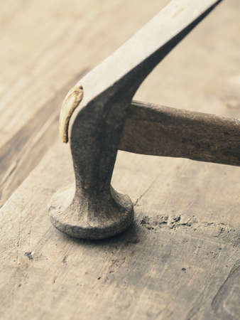 Old used vintage hammer on a wooden surfaceの写真素材